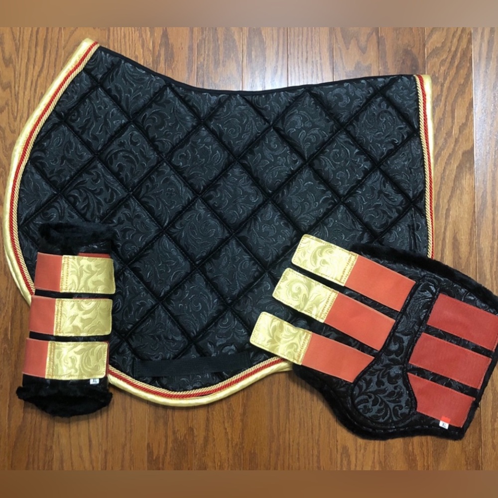 Black patterned jump cut saddle pad with gold and red cording with brushing boot